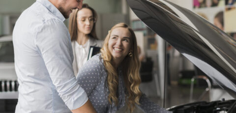 smiling-woman-checking-car-engine